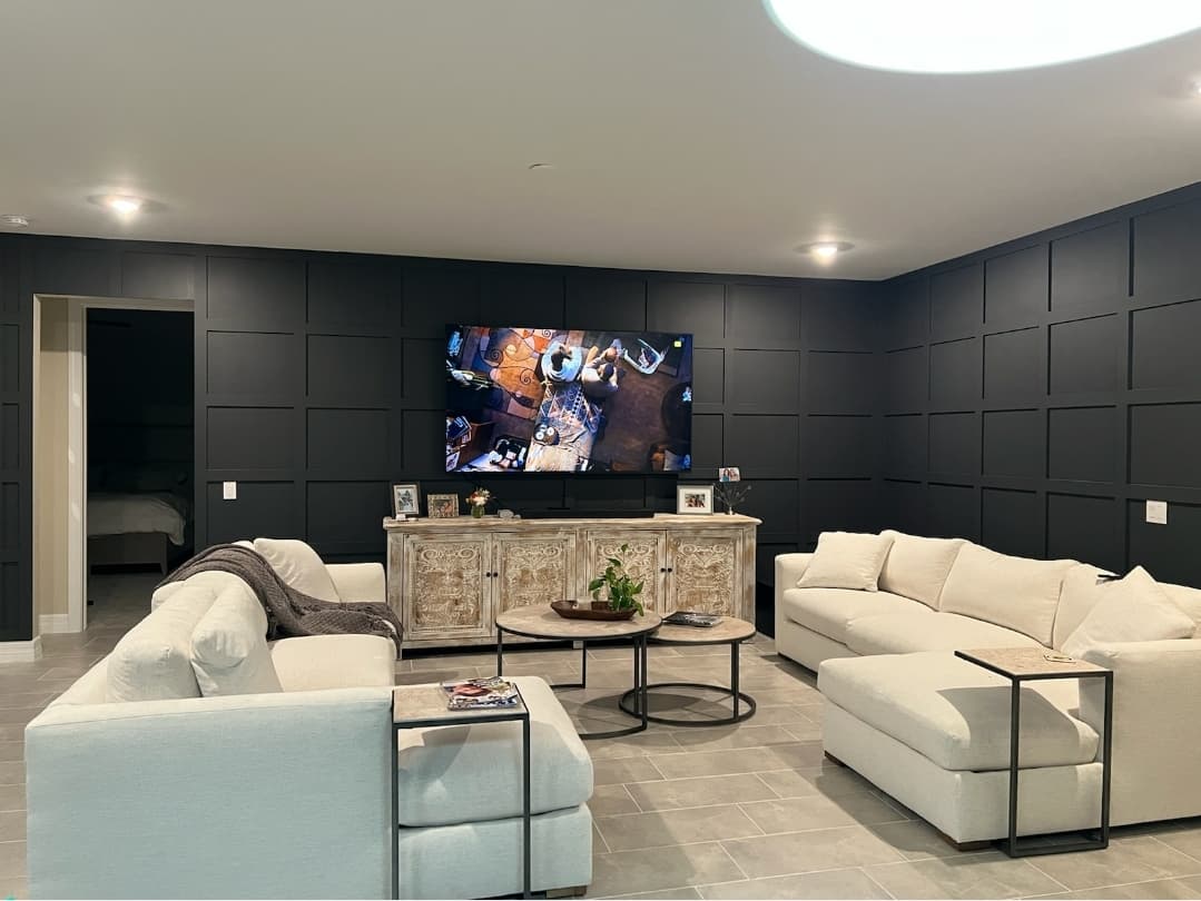 Living room with dark square-panel wainscoting and a large TV wall